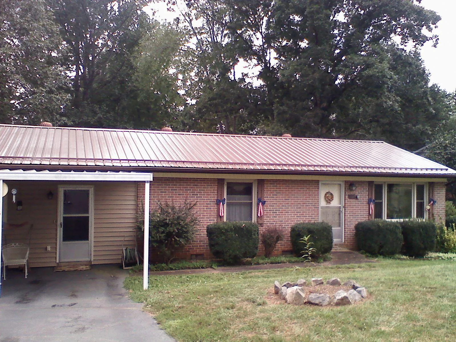 Bronze metal roof and carport on a brick ranch home — Roof Repair work by our crew in Faison
